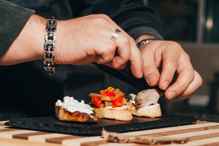 Preparing Italian bruschetta with vegetables and salmon . typical Italian antipasti starter in a restaurant .の写真素材