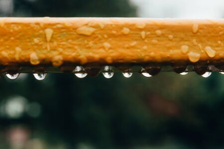 falling water drops on colored metal piece . selective focus .