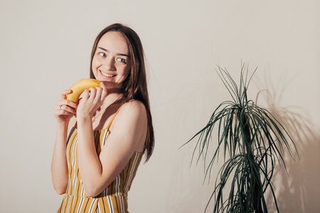 smiling girl hold in hand banana . proper nutrition concept . woman like banana .の写真素材