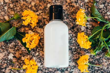 shampoo in travel bottle  with yellow tropical flowersの写真素材