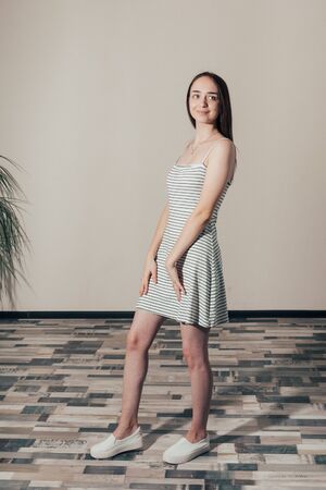 happy girl in a white dress with black stripes posingの写真素材