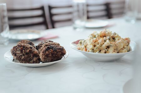 Olivier with cutlets on a plate . grandma rustic home made food concept .
