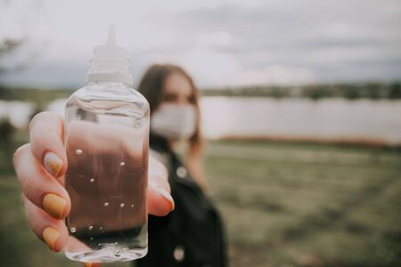 girl shows close up  antiseptic gel in her hand outside . be safe in quarantine concept . selective focus .の写真素材