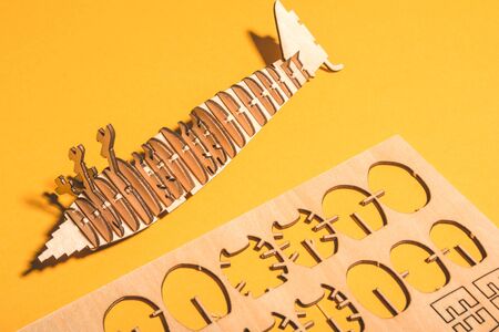 assembled wooden airplane constructor on a yellow background . children spend useful time concept .の写真素材