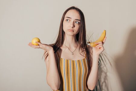 girl chooses between lemon and banana .  bisexual cocept  .の写真素材