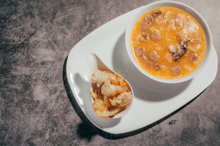 pumpkin soup with croutons on a white plateの写真素材