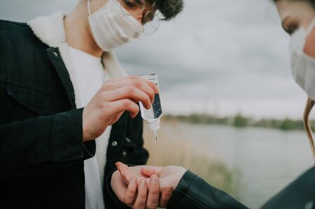 girl shows close up  antiseptic gel in her hand outside with boyfriend . selective focus .の写真素材