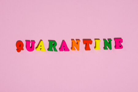 word  QUARANTINE assembled from multi  colored letters on a pink background .の写真素材