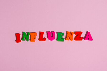 word  INFLUENZA  assembled from multi  colored letters on a pink background .の写真素材