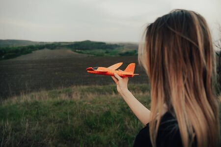 girl launches a plane in the sky outside in the fieldの写真素材