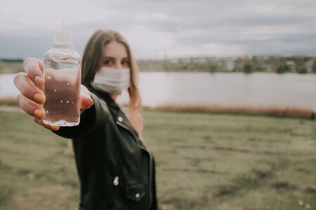 girl shows close up  antiseptic gel in her hand outside . be safe in quarantine concept . selective focus .の写真素材