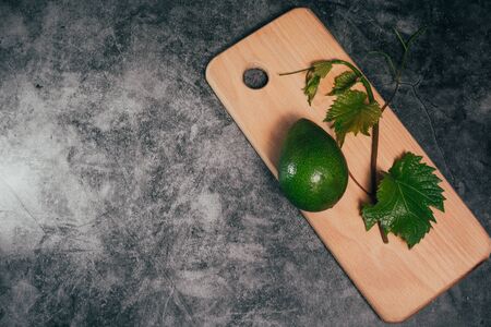 avocado on a cutting board and leaves .の写真素材