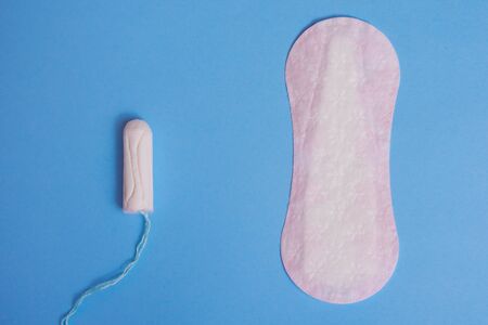 menstruation tampon and woman pads on blue background . critical days .
