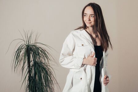 girl in a black dress and white coat posing .の写真素材
