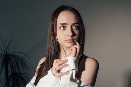 portrait of girl in a black dress and white coat posing .