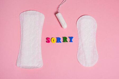 Feminine sanitary pads and tampon on pink background and word sorry . menstruation time concept .の写真素材