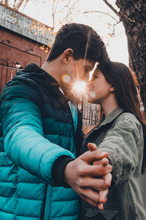 guy and girl kiss in the park. sun rays between the lips of lovers.の写真素材