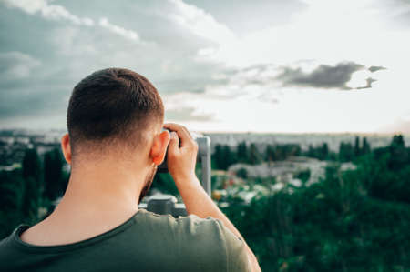 man watch in telescope with city skylineの写真素材