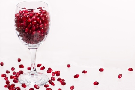 Pomegranate seeds in glass on the whiteの写真素材