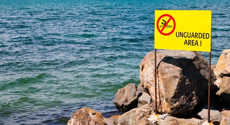 beach warning sign of Unguarded Beach の写真素材