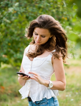 Outdoor portrait of young woman with phoneの写真素材