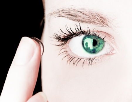 Close up of inserting a contact lens in female eye の写真素材