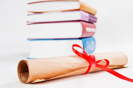 Diploma with red ribbon and books の写真素材