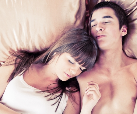 Young couple sleeping in a bedの写真素材