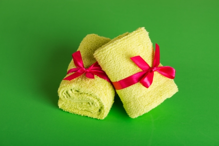 rolled up green beach towel on green background の写真素材
