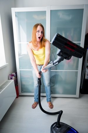 Woman cleaning the house with the Vacuum Cleaner の写真素材