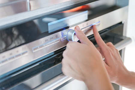 Hand moving the timer knob on the oven の写真素材