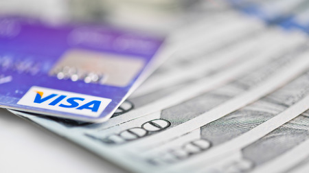 YEKATAERINBURG, RUSSIA - APR 25, 2014: Visa Debit Cards Over Dollar bills のeditorial素材