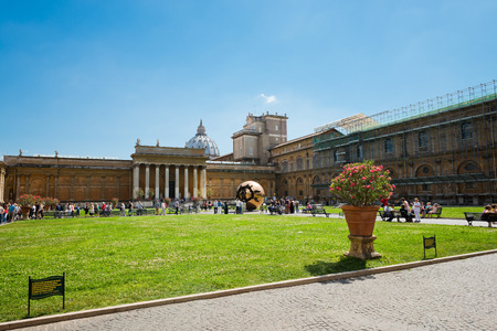VATICAN CITY, VATICAN - JULY 15 2014: People around Sphere within sphere in Courtyard of the Pinecone at Vatican Museums. Sphere was created in 1990 by Italian sculptor Arnoldo Pomodoro. のeditorial素材