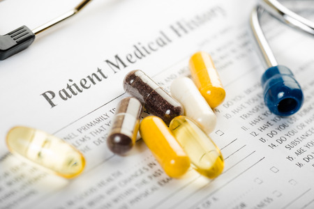 Medical history document with medicine and stethoscopeの写真素材
