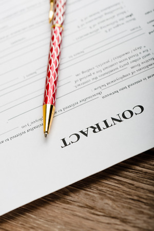 Pen and contract papers on wooden deskの写真素材