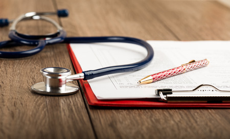 medical history with stethoscope and pen on wooden desk medical history with stethoscope and pen on wooden desk