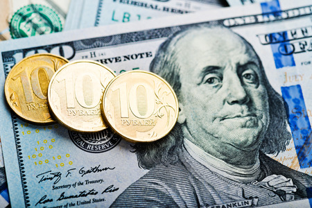 russian roubles coins on banknotes of us dollars