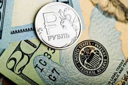 russian roubles coins on banknotes of us dollarsの写真素材