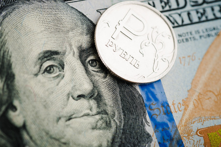 russian rouble coin on banknotes of dollars