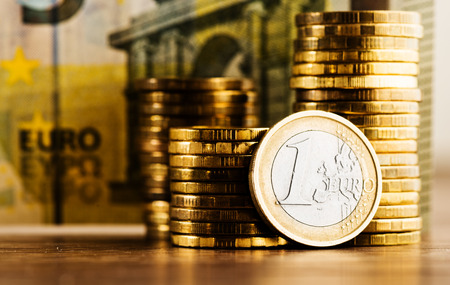 one euro coin and gold money on the deskの写真素材