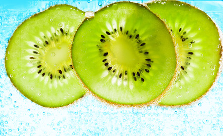sliced kiwi covered with bubblesの写真素材