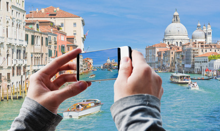 Tourist taking a picture of Grand Canal and Basilica Santa Maria della Salute in Venice, Italyの写真素材