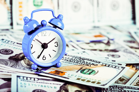 Time is money. Alarm clock and dollar banknotes.の写真素材
