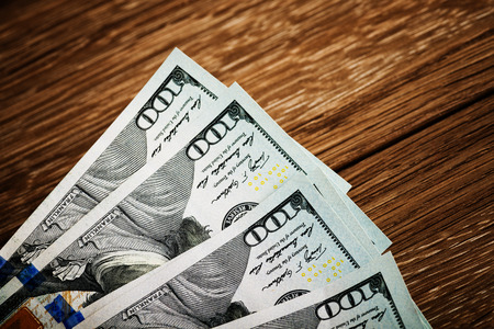 new 100 US dollars 2013 edition banknotes (bills) on wooden background