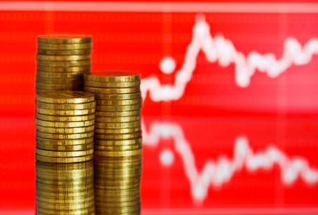 gold money. Fluctuating graph on red background.の写真素材