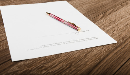 Pen and contract papers on wooden deskの写真素材