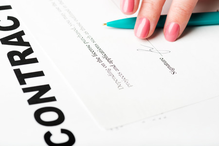 female hand signing a contract.の写真素材