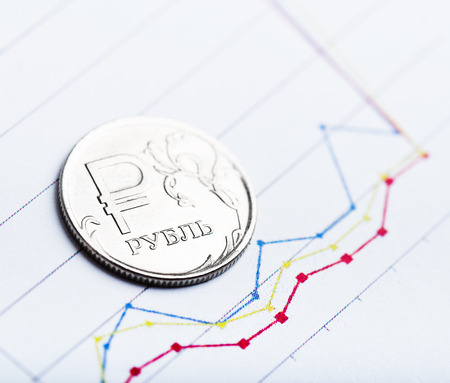 One rouble coin on fluctuating graph. Rate of the Russian rouble (shallow DOF)の写真素材