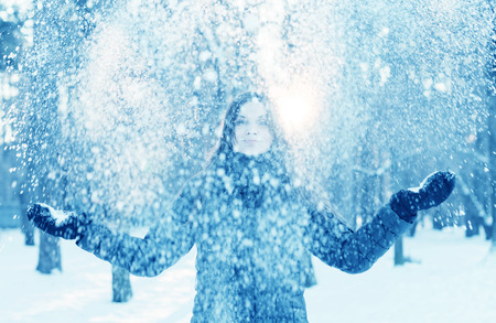 Happy young woman having fun in the snowの写真素材