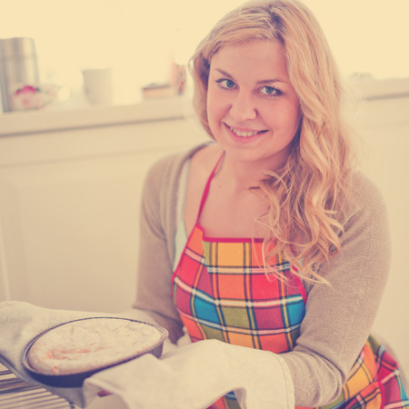 Woman pulling pie from oven .の写真素材